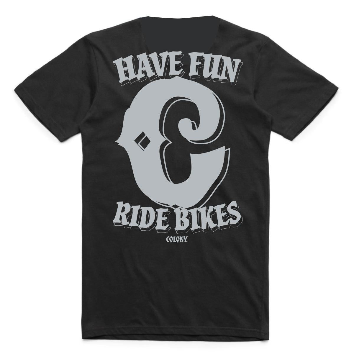 The Colony Have Fun T-Shirt is a black, 100% carded cotton tee featuring bold gray "HAVE FUN & RIDE BIKES COLONY" text on the front—a classic for any Colony collection.