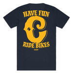 The Colony Have Fun T-Shirt is a navy blue tee made from 100% carded cotton, featuring bold yellow "Have Fun Ride Bikes" text and "Colony" underneath on the back.