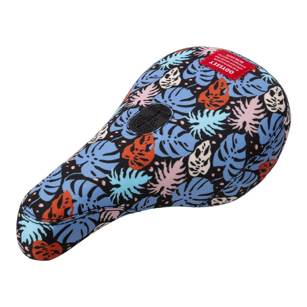 The Odyssey Tropical V1 Pivotal Seat features sublimated artwork with blue, orange, and white tropical leaves on a black background, creating vibrant tropical vibes. It also includes a small red tag attached to the top.