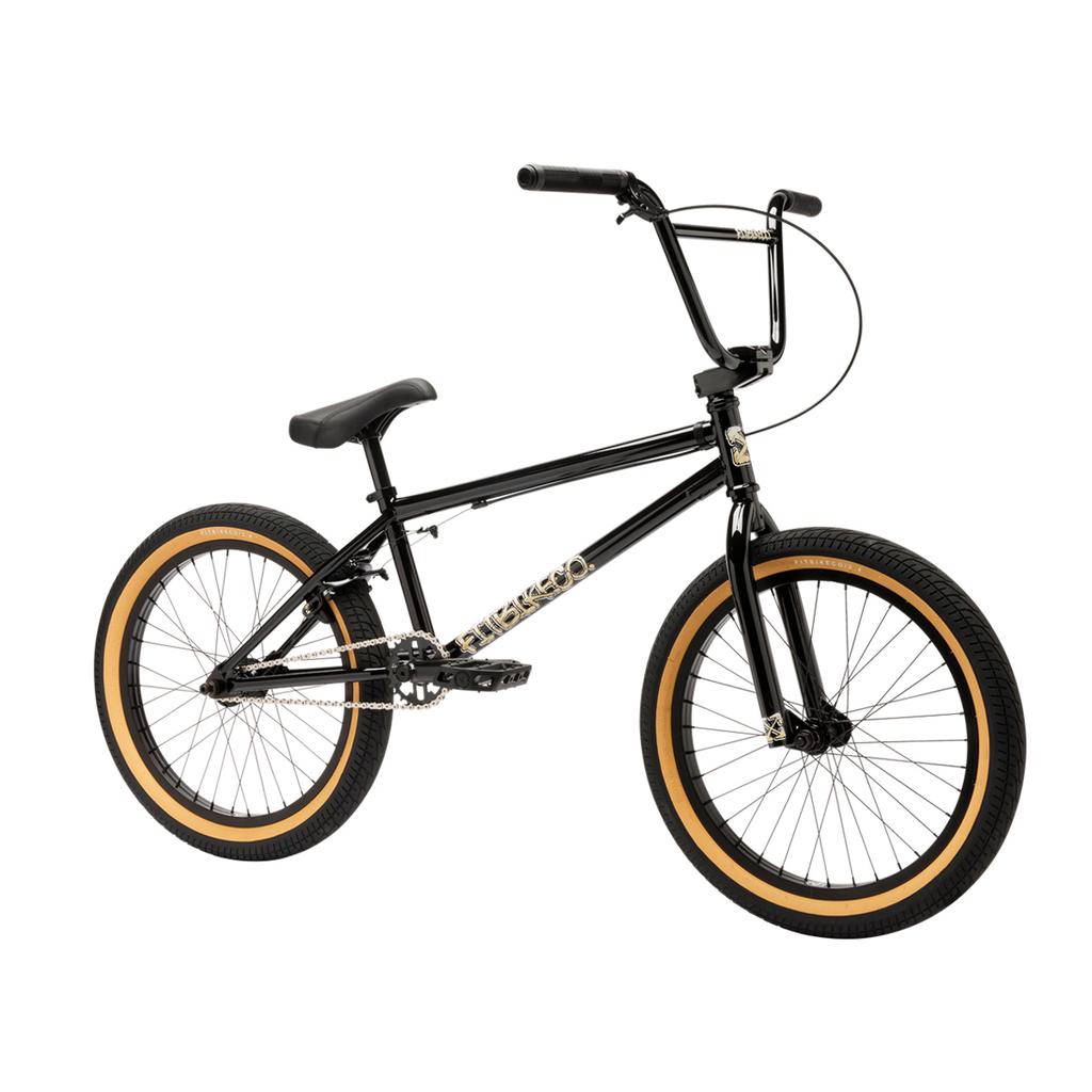 The Fit Bike Co Series One Bike in black features tan wall tires, a straight top tube, and a raised handlebar, displayed on a white background.