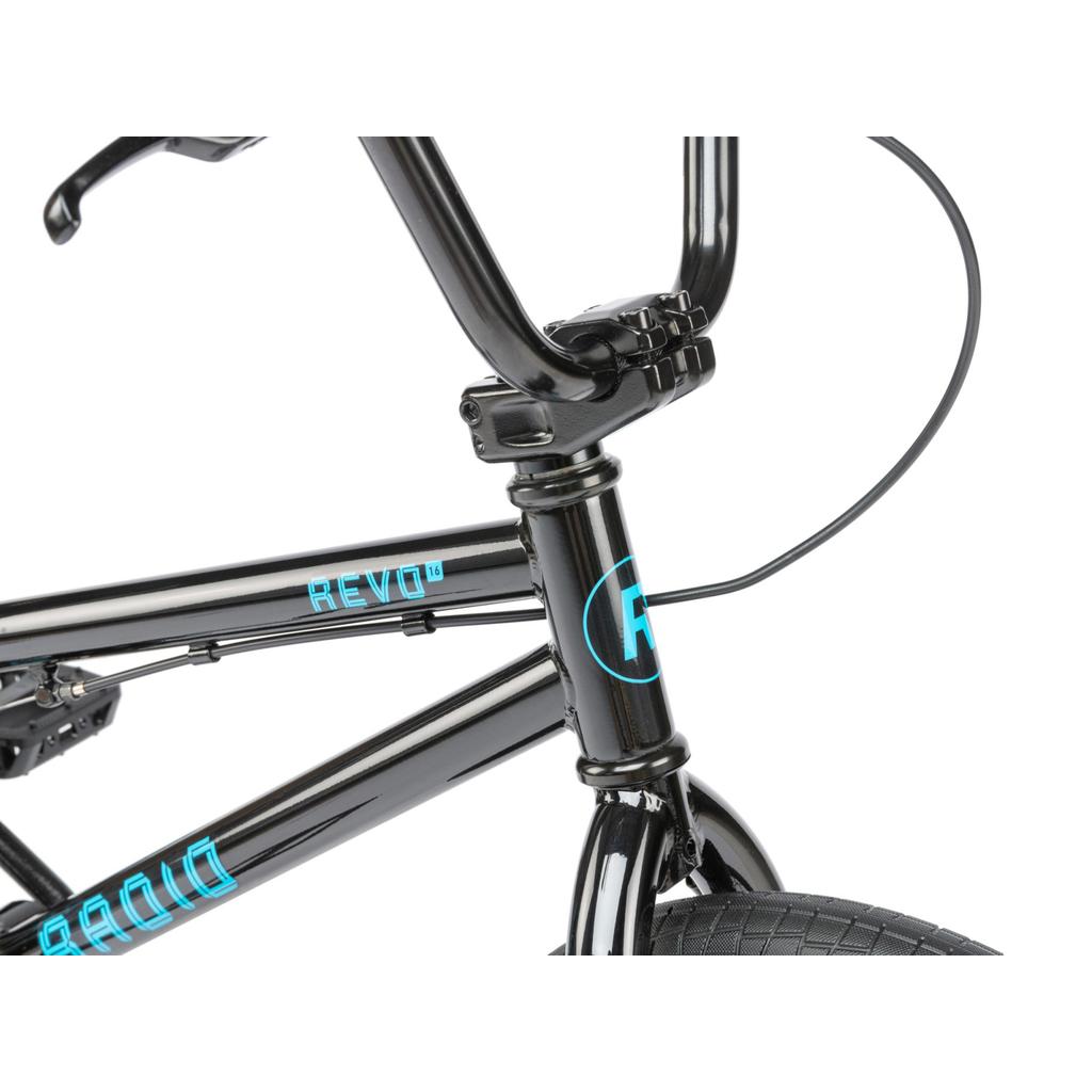 Close-up of the Radio Revo 16 Inch Bike's black front frame, handlebars, and tire, featuring blue "REVO" and "R" logos. Ideal outdoor bicycle for young riders.