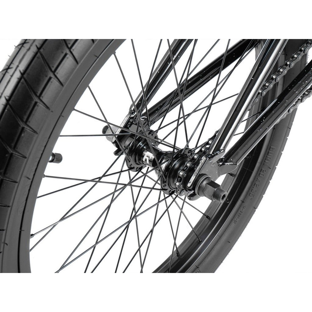 Close-up view of the rear wheel on a black Radio Astron FS 20 Inch Bike, highlighting the spokes, tire, Radio Pro Hubs, and part of the chain.