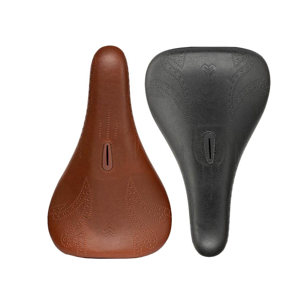 Two Eclat Exile Pivotal Tyson BMX seats, one brown and one black, each featuring a central cutout and perforated design, are displayed side by side on a white background.