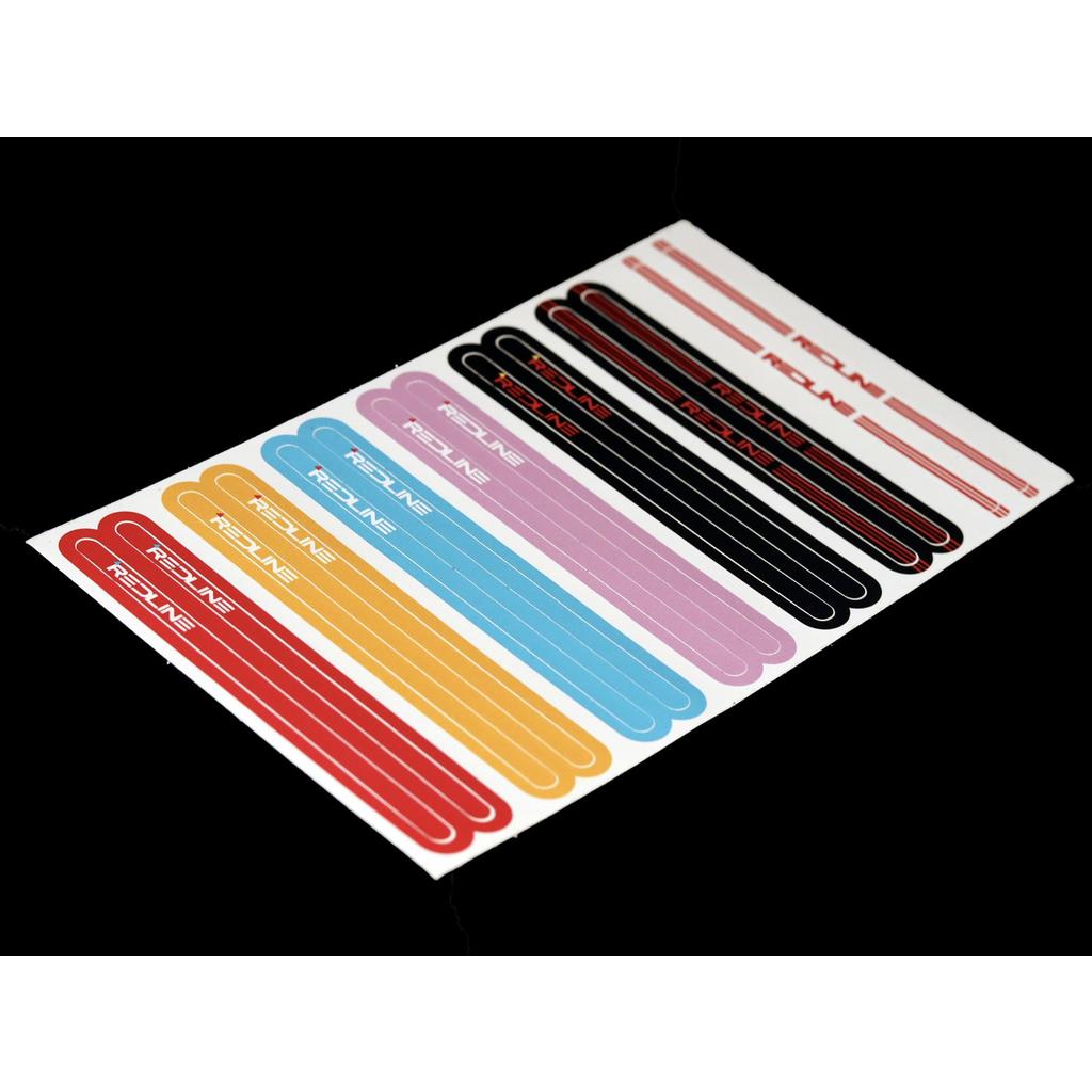 A sheet of assorted Redline Vintage Flight 401 Pinchless Crank Set stickers, featuring various colors and sizes inspired by 1980s BMX, displayed in rows on a black background.