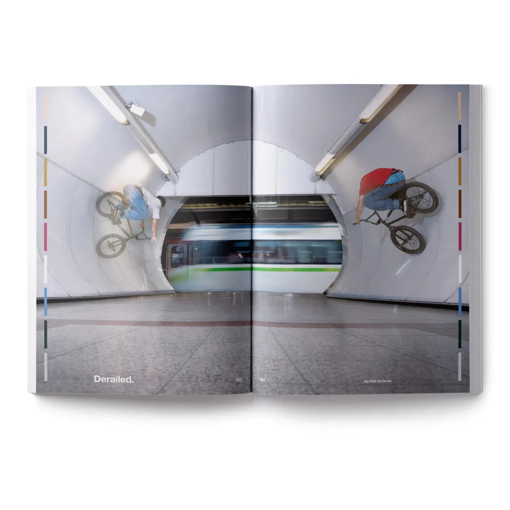A person rides a BMX bike on a subway tunnel wall as a train passes by—an adrenaline-filled moment you’ll find captured in DIG Book Issue 2025.