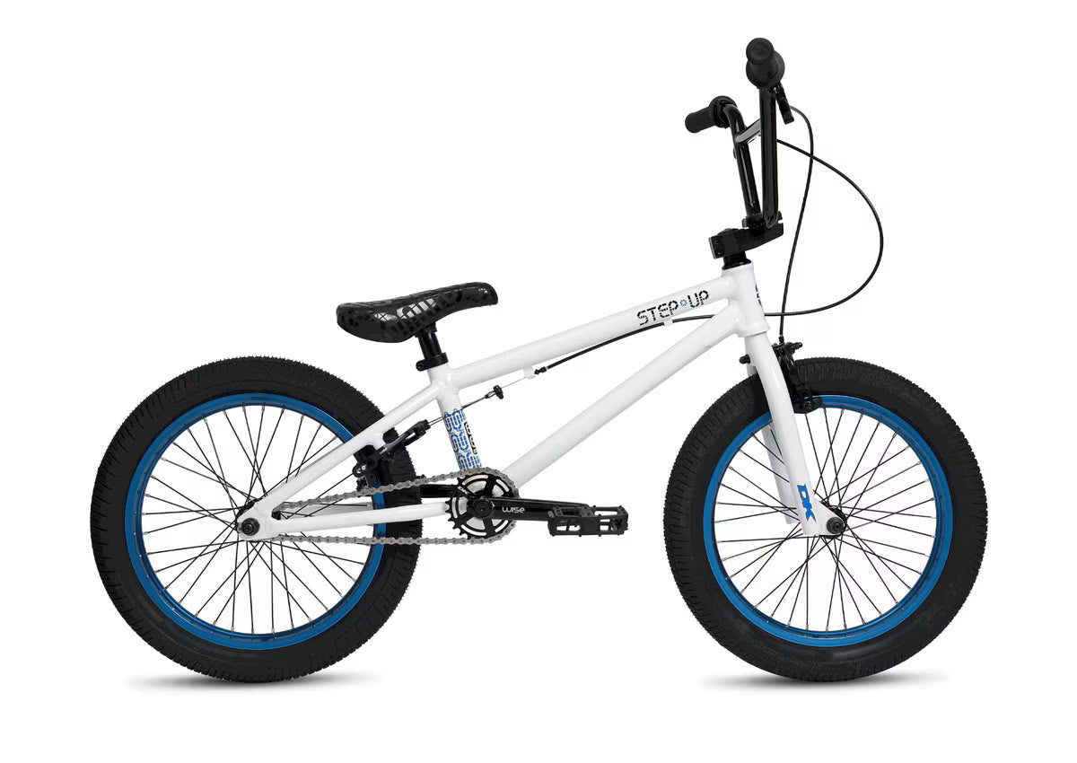 The DK Step Up 18 Inch Bike is shown from the side against a plain background, featuring a white frame, black handlebars, seat, and pedals, blue wheel accents, and a lightweight 6061 aluminum construction.