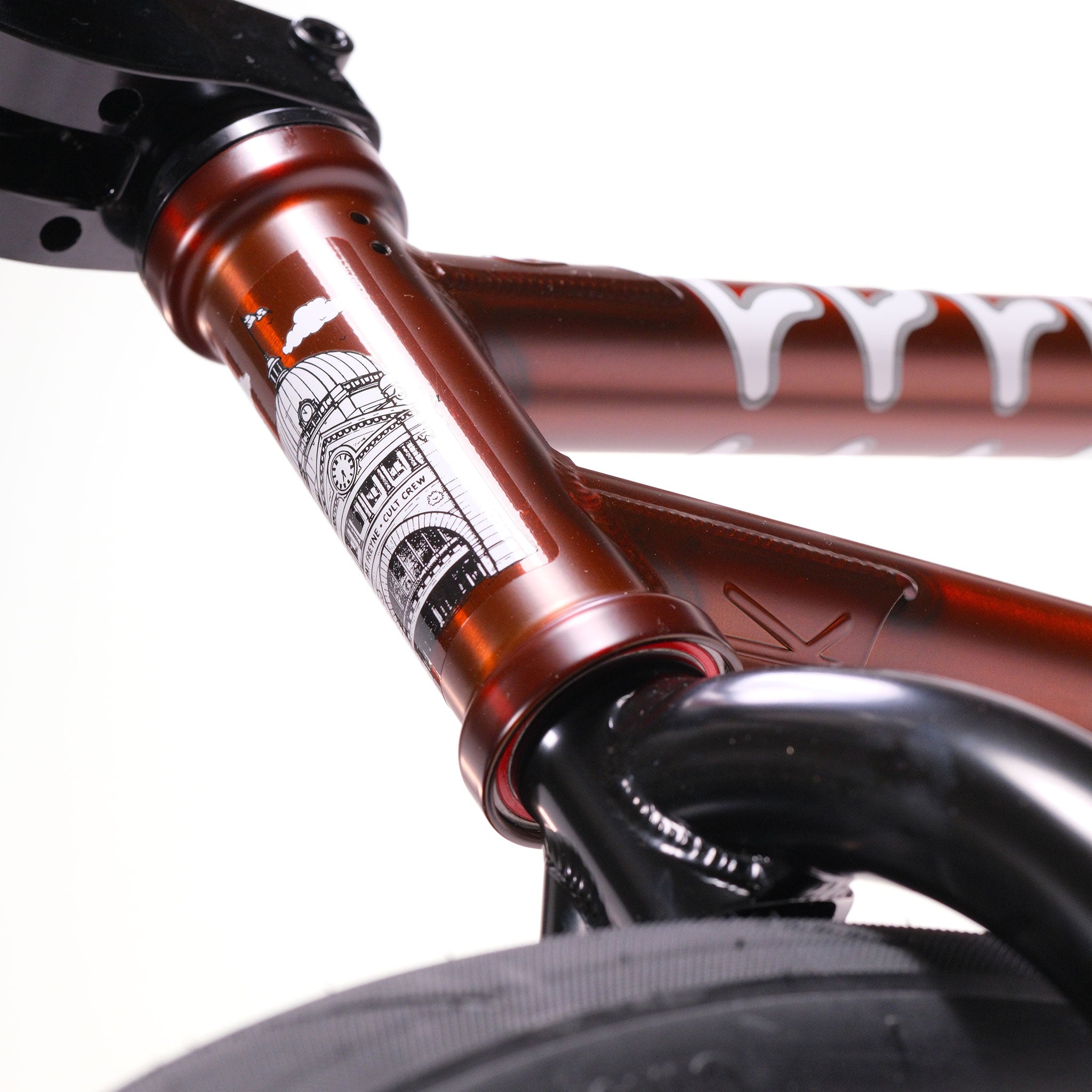 Close-up of the Cult Dak X Eclat Custom 'Pat Freyne Signature' BMX bike with a metallic finish, detailed building illustration, Pat Freyne signature, white lettering, and part of the tire visible in the foreground.