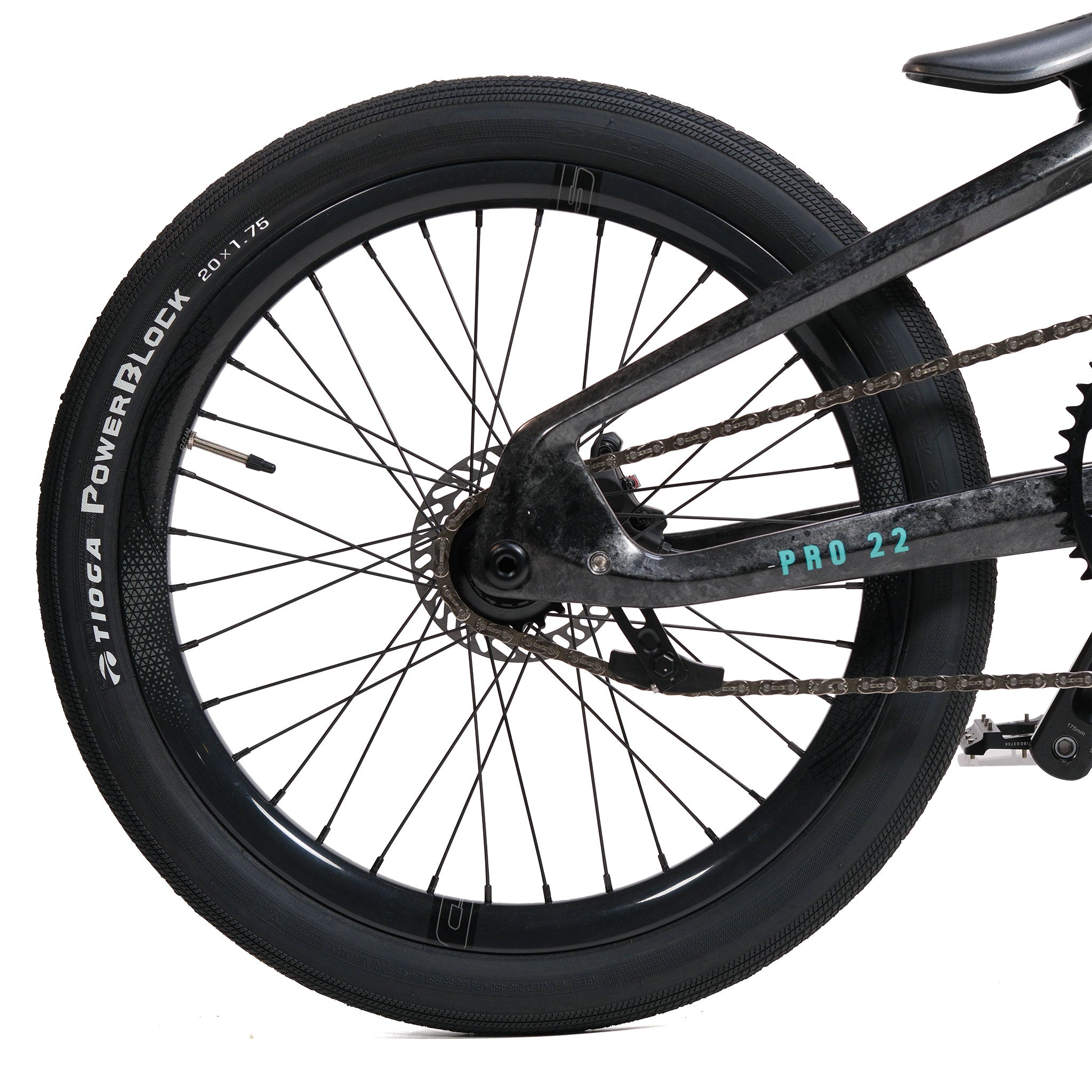 Close-up of a black bicycle’s rear wheel, chain, and part of the frame. The tire sidewall reads "Tioga PowerBlock 20x1.75" and the frame is labeled "PRO 22." This setup features the distinct profile often seen on high-performance carbon BMX race bikes like the Meybo HSX Carbon Pro XXL Race Bike.