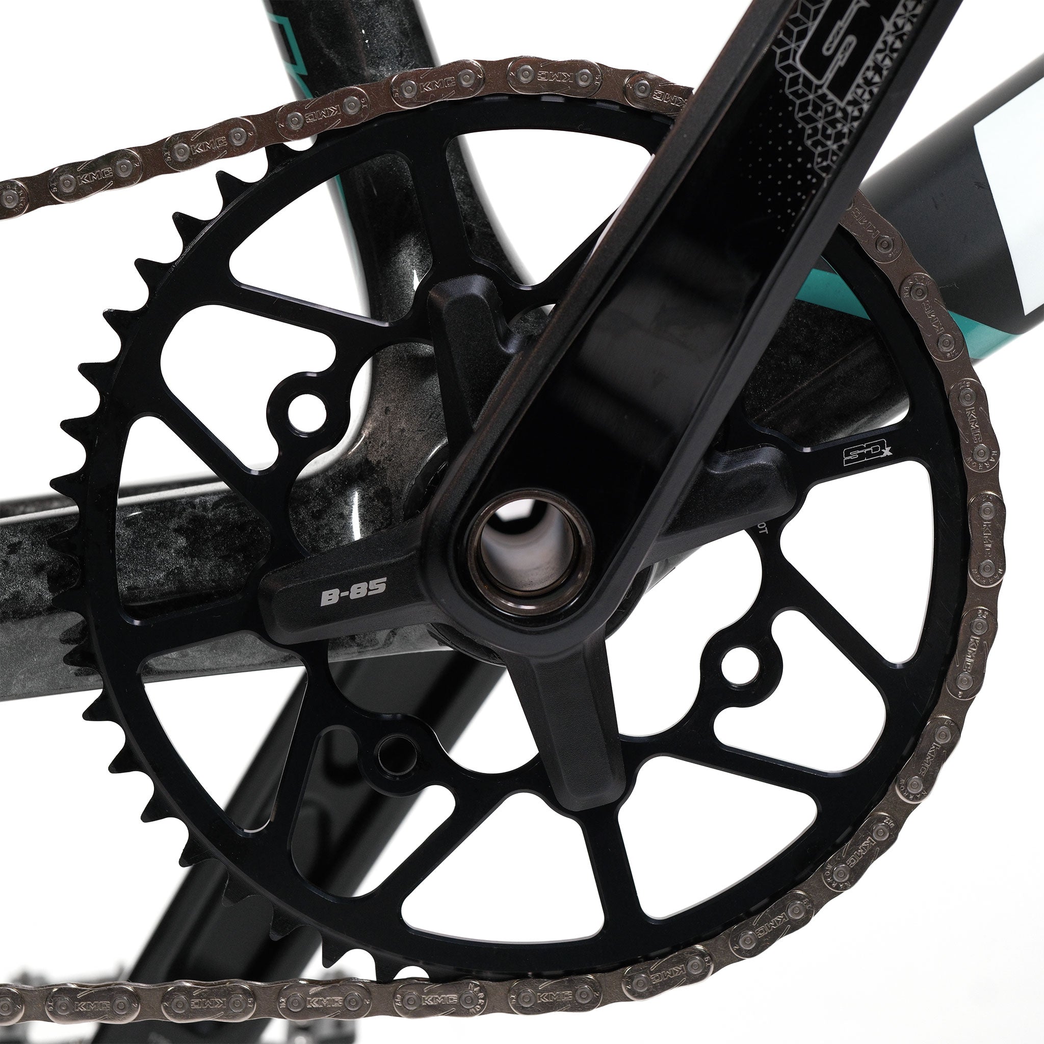 Close-up of a black bicycle crankset and chainring with a chain attached, mounted on a Meybo HSX Carbon Pro XXL Race Bike frame.