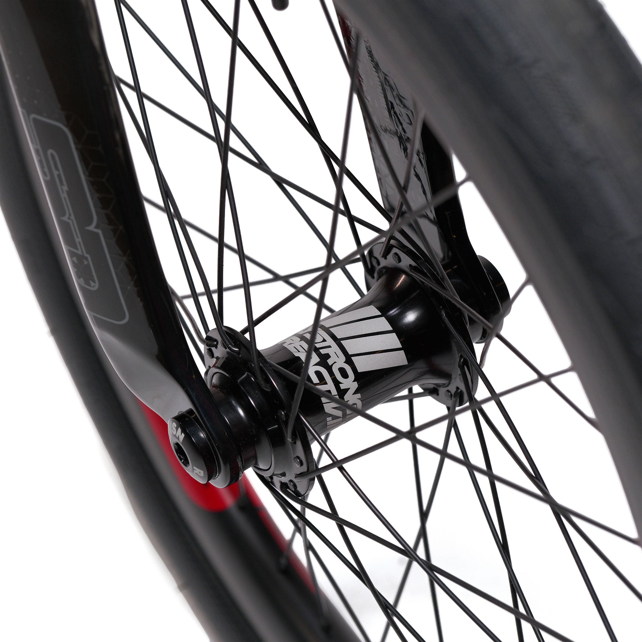 Close-up view of a black bicycle wheel hub with spokes, featuring white text on the hub, along with part of the tire and rim—an ideal complement for the Stay Strong V5.1 Pro XXXL Race Bike or custom race bikes built with precision aluminium frames.
