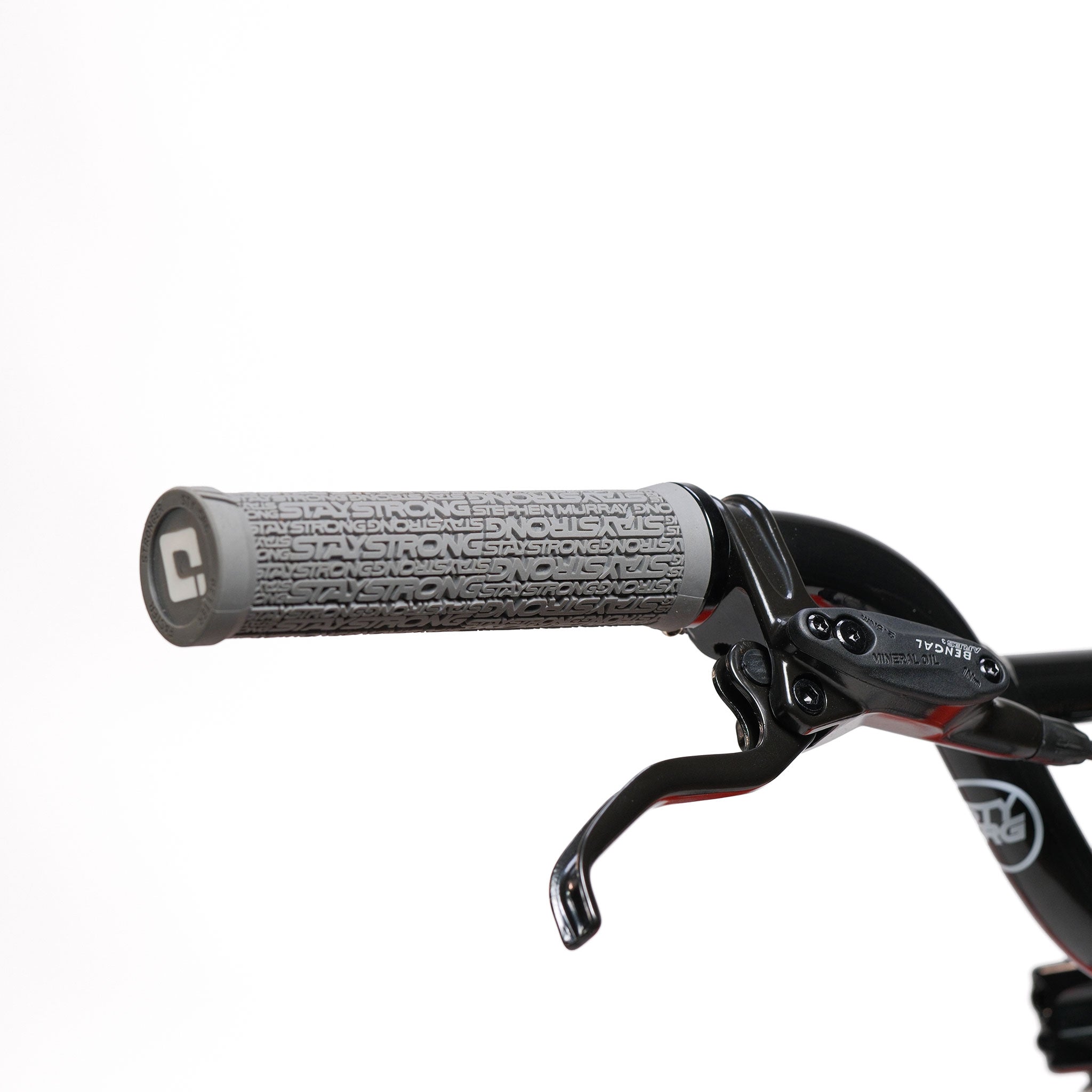 Close-up of the Stay Strong V5.1 Junior Race Bike handlebar featuring a gray textured grip and black brake lever against a white background, highlighting the lightweight aluminium construction.