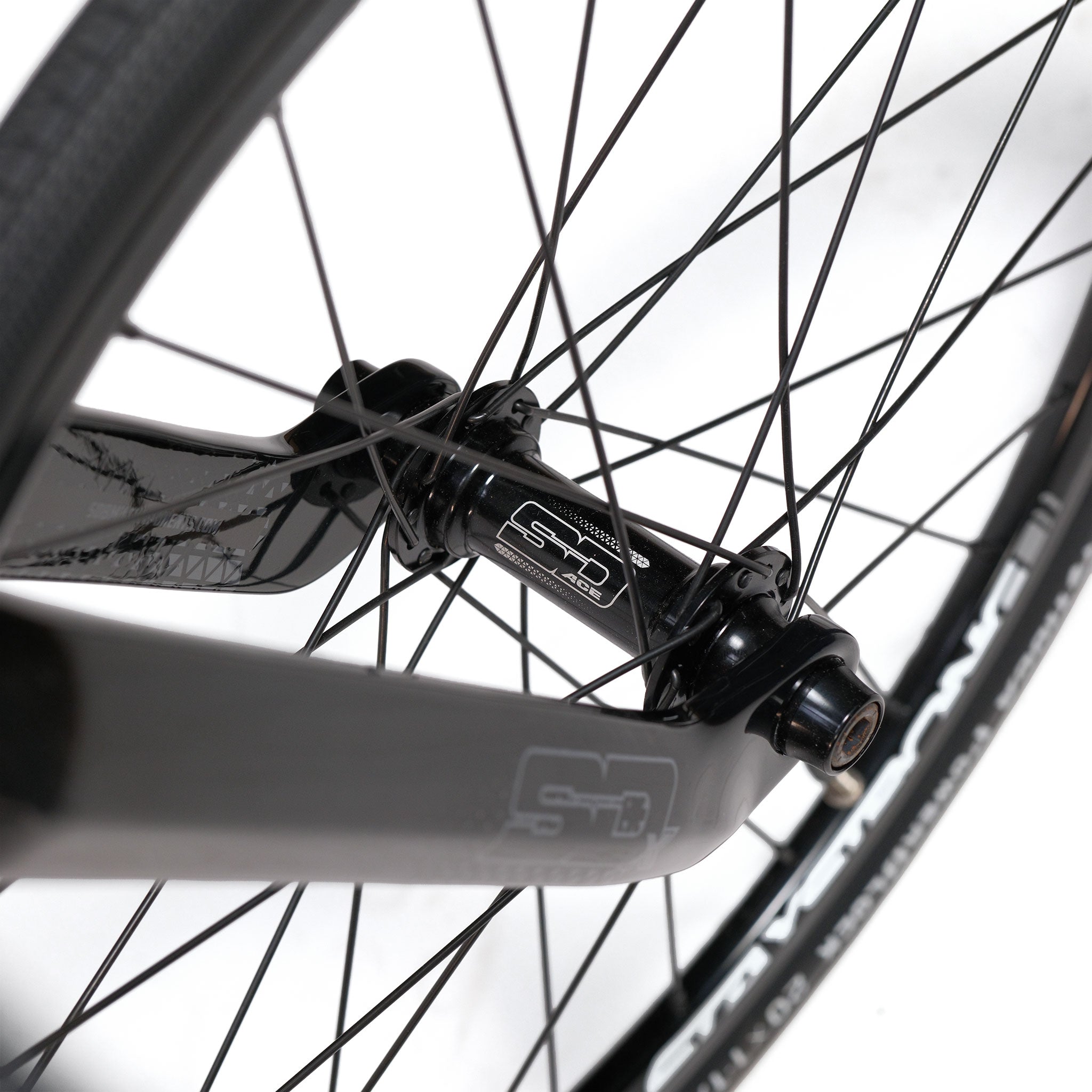 Close-up view of a lightweight aluminium wheel on the Stay Strong V5.1 Junior Race Bike, featuring black spokes, a hub with "SD" branding, and part of a black fork—details that highlight the bike’s precision engineering designed for BMX racing.