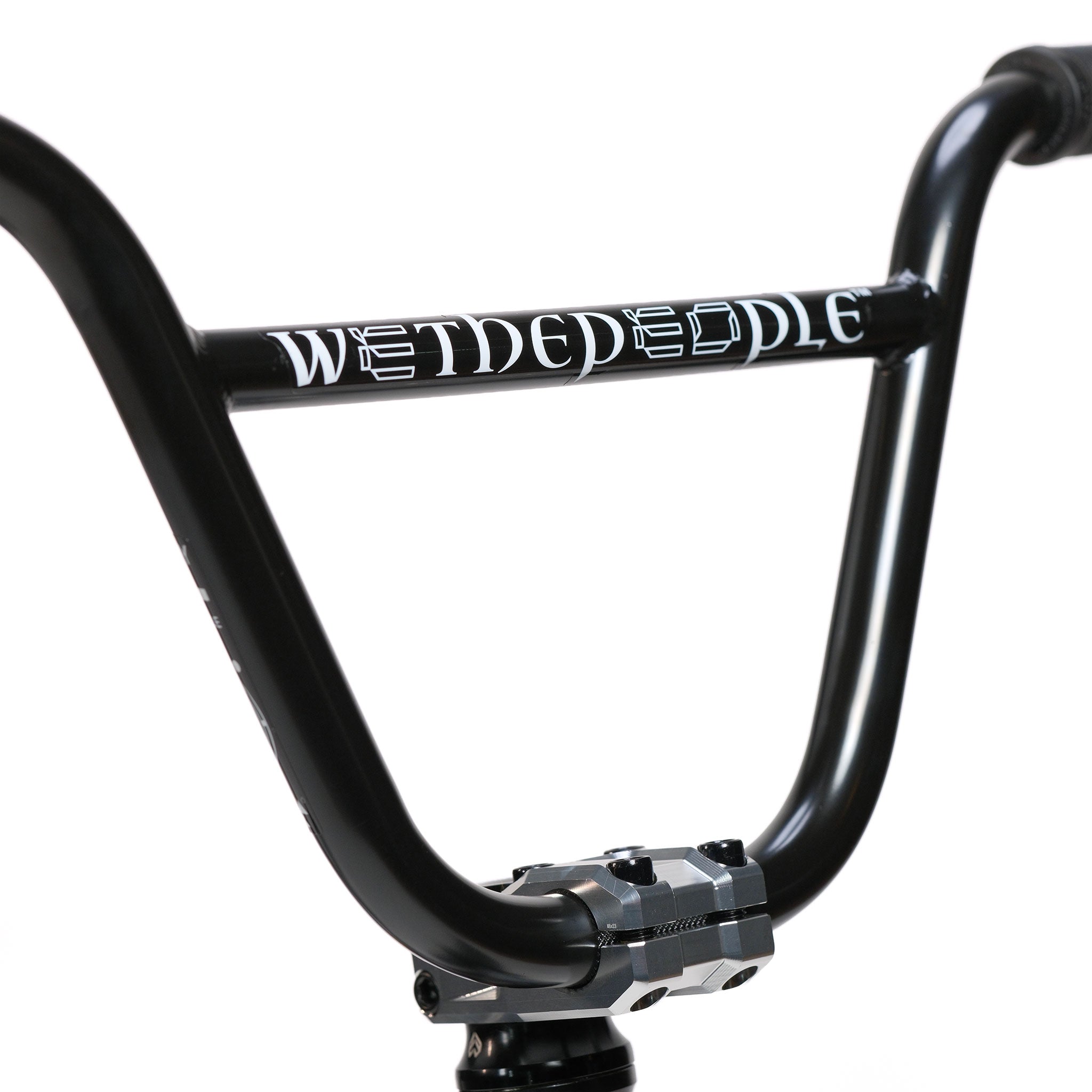 Close-up of black BMX handlebars with “WETHEPEOPLE” written in white on the crossbar, attached to a silver stem, against a plain white background—ideal for riders wanting to upgrade their Wethepeople Prodi-G-Unit 18 Inch Custom Bike or personalize their BMX setup with premium Eclat components.