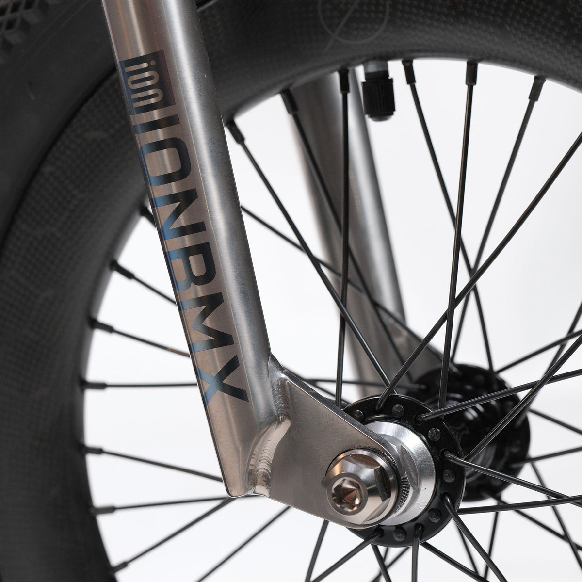Close-up of the lightweight front wheel and metallic fork of the ION BMX Ti16 Custom Titanium 16 Inch Bike, with “ION BMX” branding visible on the fork and black spokes radiating from the hub, highlighting the compact design characteristic of 16 inch BMX models.