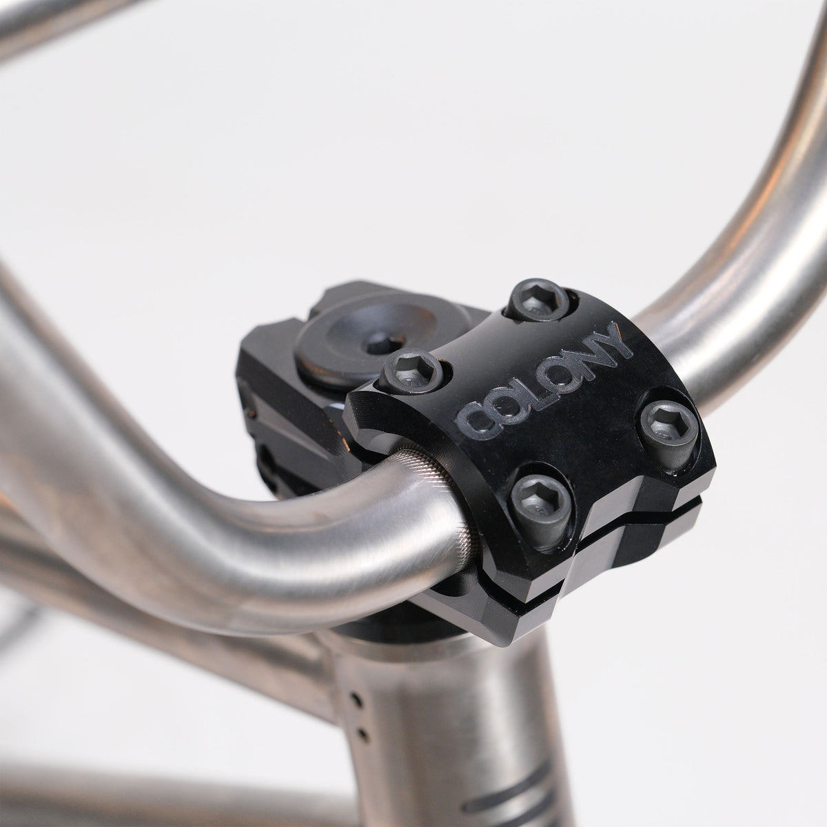 Close-up of a lightweight handlebar on the ION BMX Ti16 Custom Titanium 16 Inch Bike, featuring a black COLONY stem clamp with four bolts securing the handlebar to the stem.