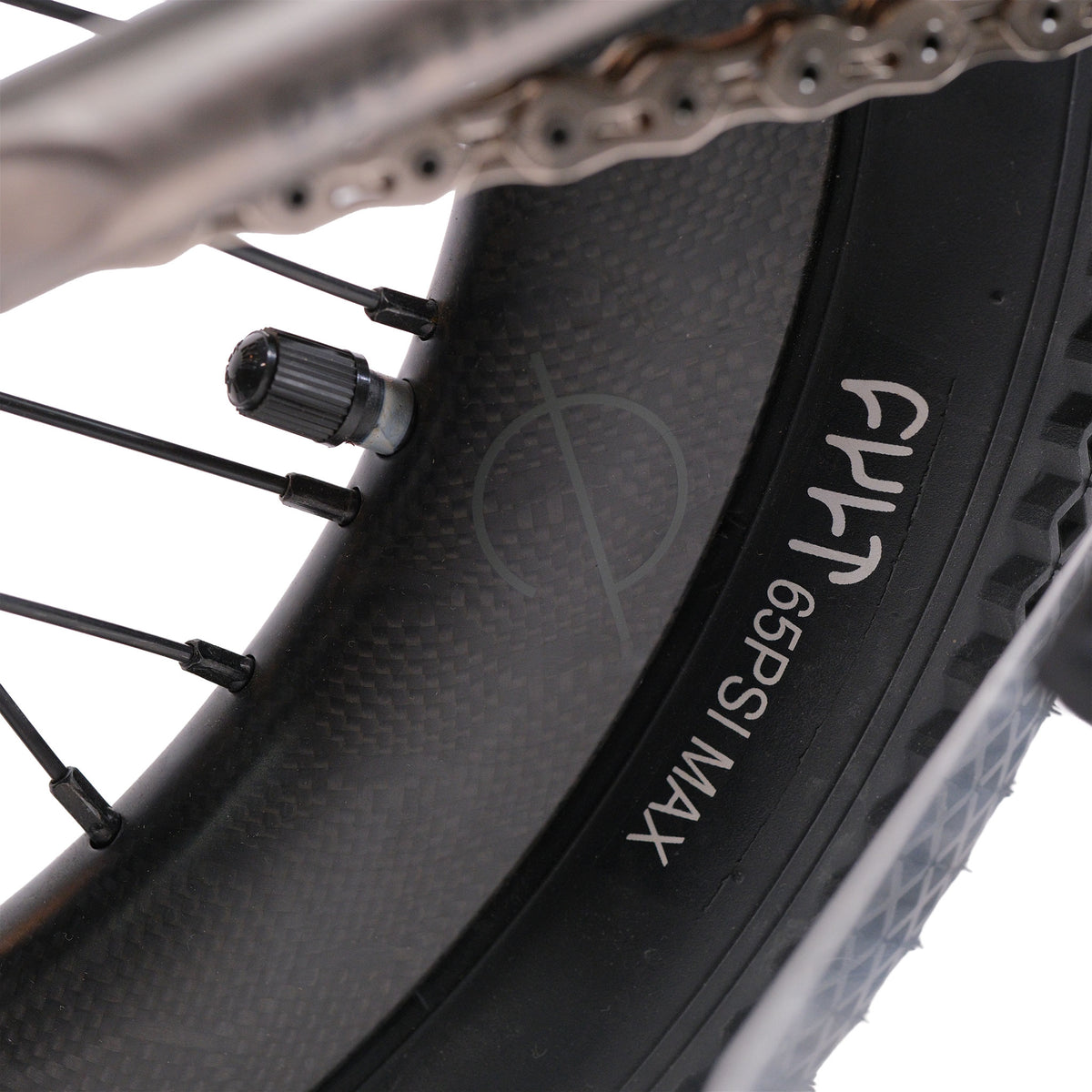 Close-up of the ION BMX Ti16 Custom Titanium 16 Inch Bike wheel, highlighting the lightweight design, tire sidewall with “FHT 65 PSI MAX” text, valve stem, spokes, and part of the metal chain.