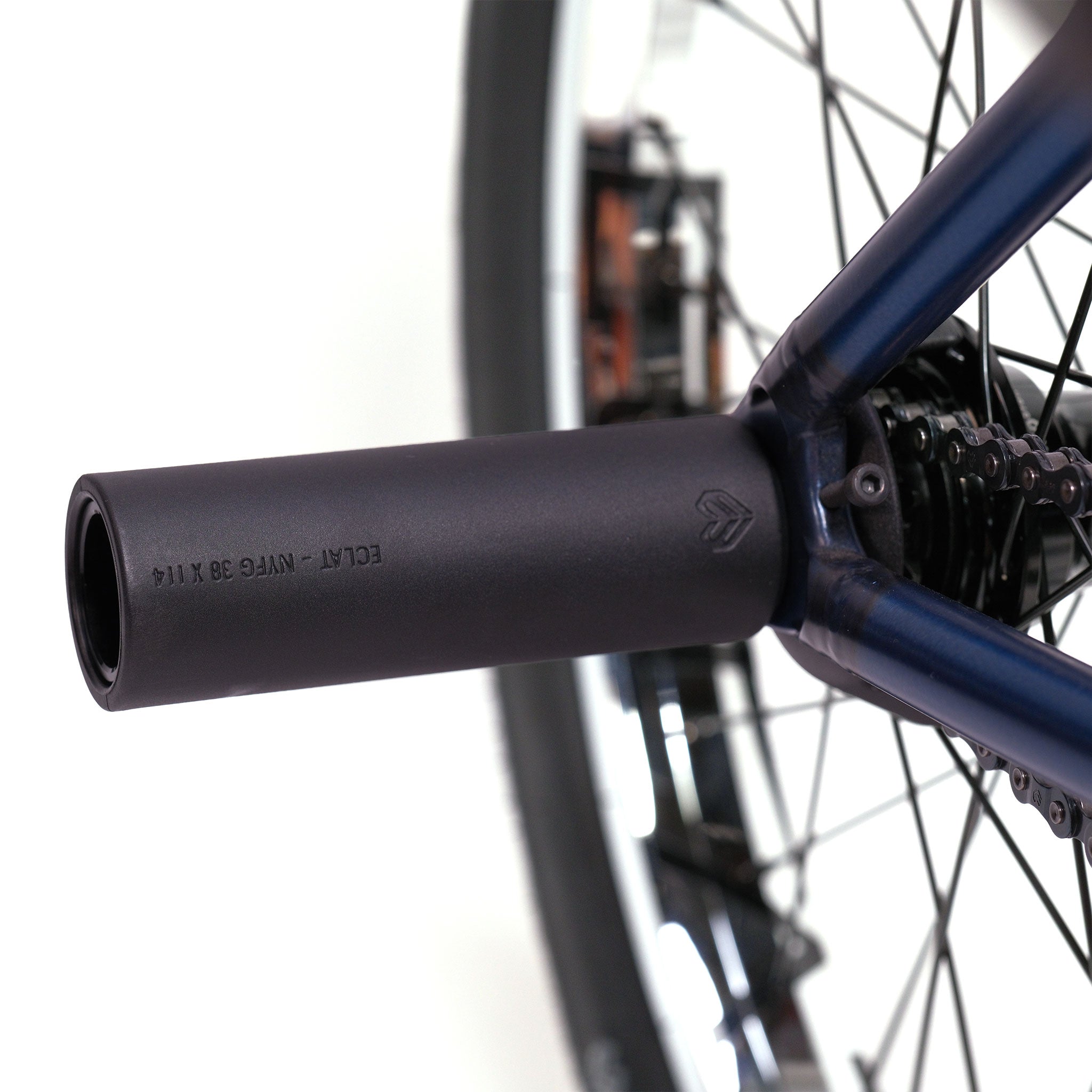 Close-up of the Wethepeople Tomorrow X TA Custom build BMX showcasing its rear wheel with a black cylindrical axle peg, visible spokes, and part of the brake disc.