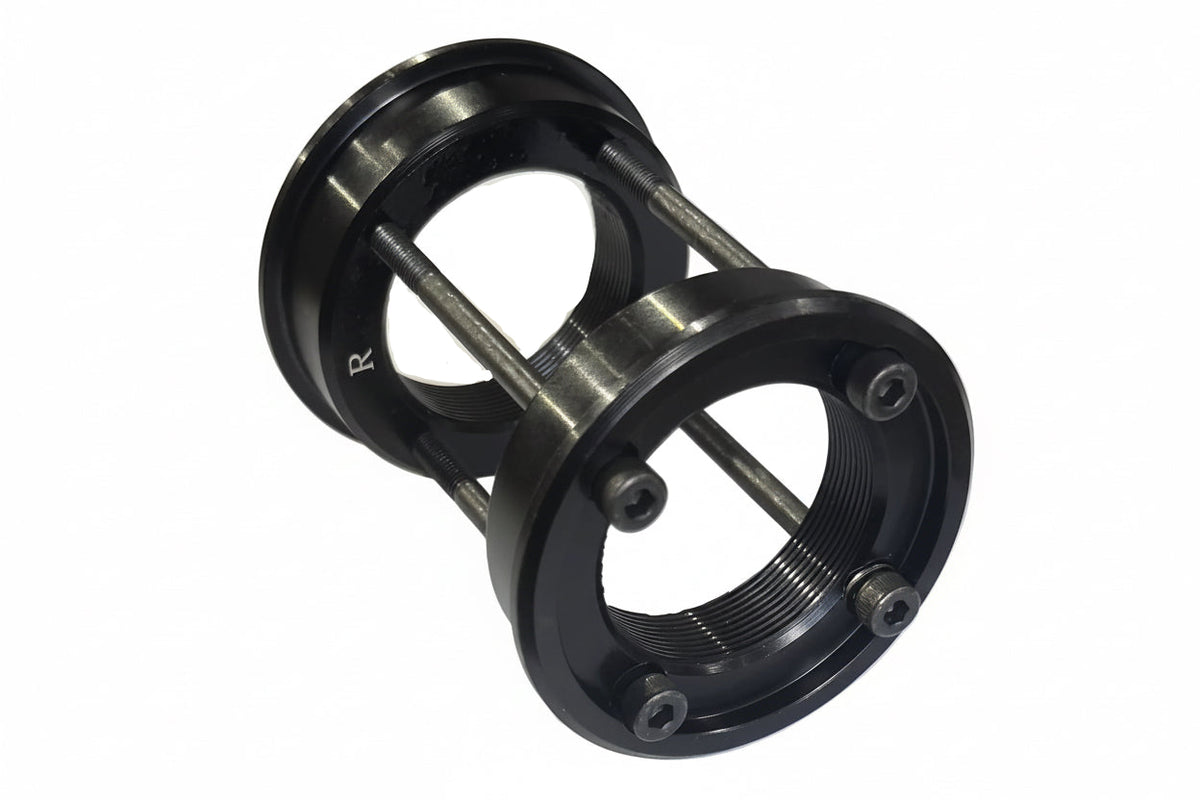 A USA to BSA Bottom Bracket Conversion Kit, featuring black metal threaded euro BB cups connected by bolts and spacers, is shown against a white background.