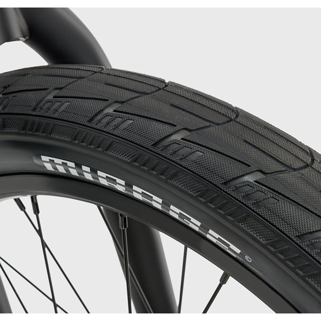 Close-up of a black Eclat Mirage Folding Tyre, highlighting its textured tread pattern and white "MIRROR" text. It includes a high-performance 120tpi casing for durability against a plain, light-colored background.