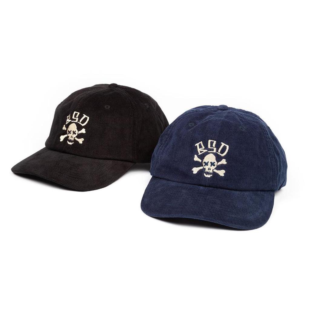 The BSD More Speed Cap is a classic corduroy 6-panel cap, available in black or navy, featuring a skull and crossbones with "BSD" embroidered above—ideal for fans of the BSD collection.