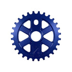 The S&M X-Man Sprocket is a blue, CNC-machined 7075 T6 aluminum chainring with 1/8" teeth, a shield logo, and "S&M BIKES" engraved at the bottom. Made in the USA.