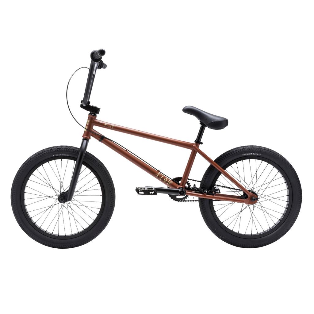 The Fit Bike Co Flow 20 Inch Bike features a brown and black BMX-style design with a compact frame, thick tires, and straight handlebars—ideal for tackling dirt jumps and trails. Shown in side profile on a white background.