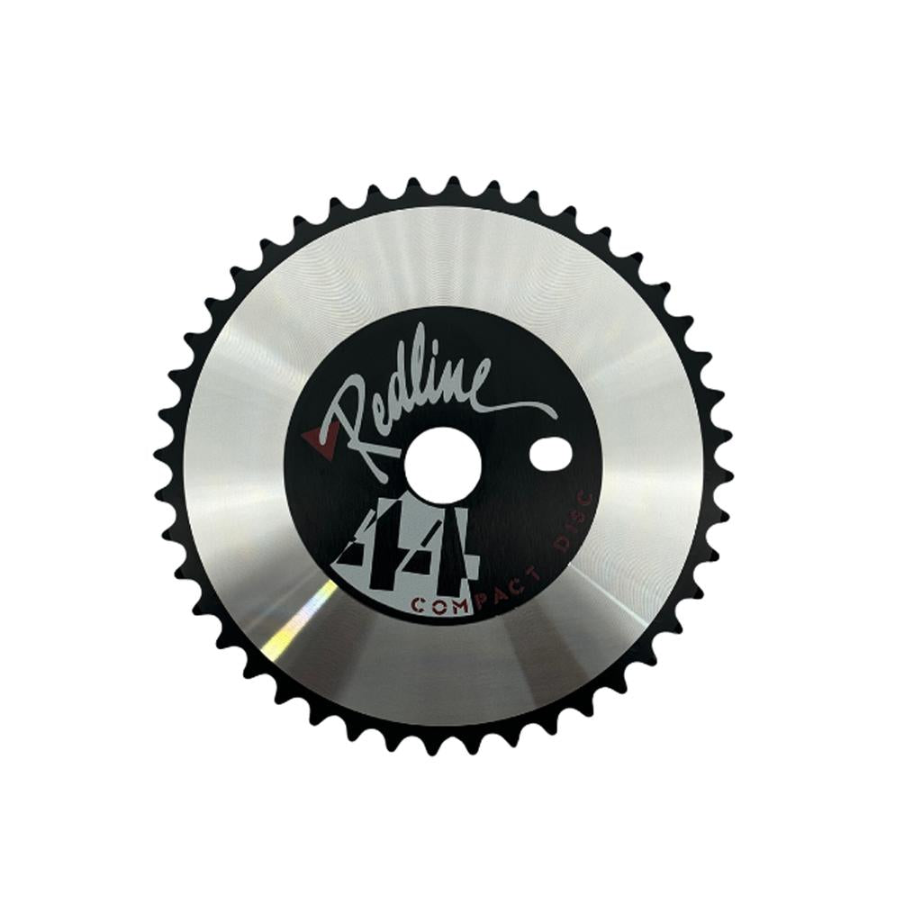 The Redline By Kastan Power Disc Front Sprocket is a circular 44t chainring made from 6061 alloy, featuring "Redline" branding and "44T COMPACT DISC" text at the center.