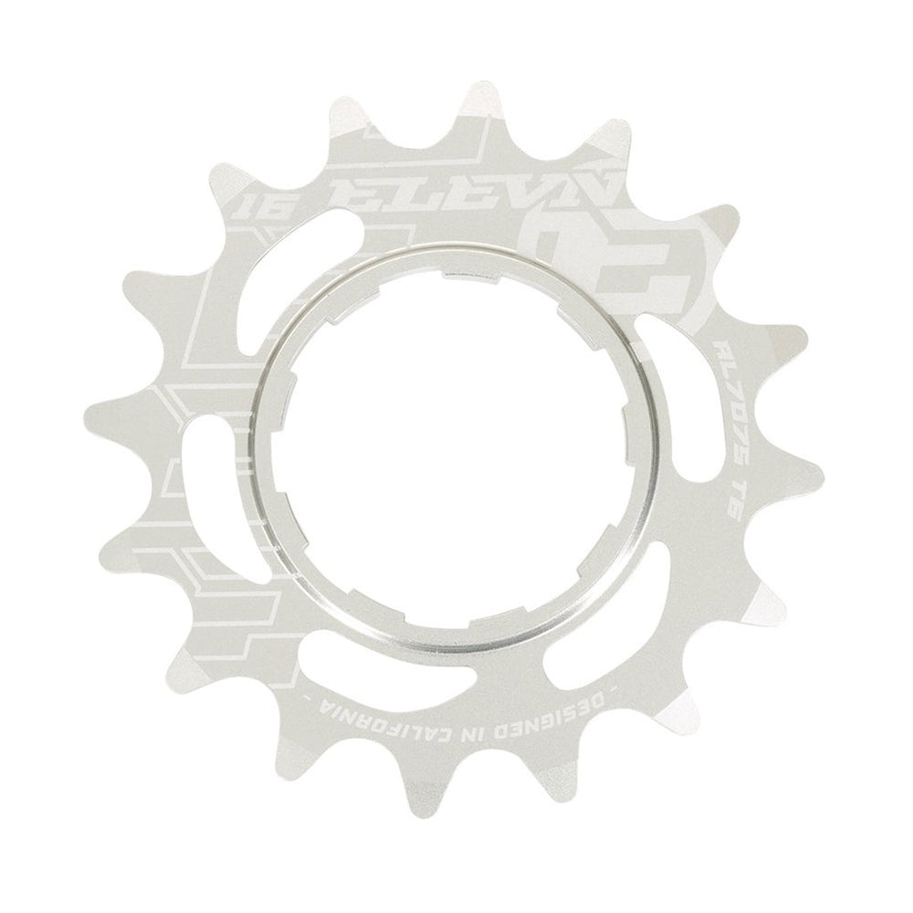A silver Elevn Cro-Mo Cog 3/32 Shimano Comp with intricate cut-outs and text engravings including the phrases "designed in California," "SRAM," and "Shimano compatible.