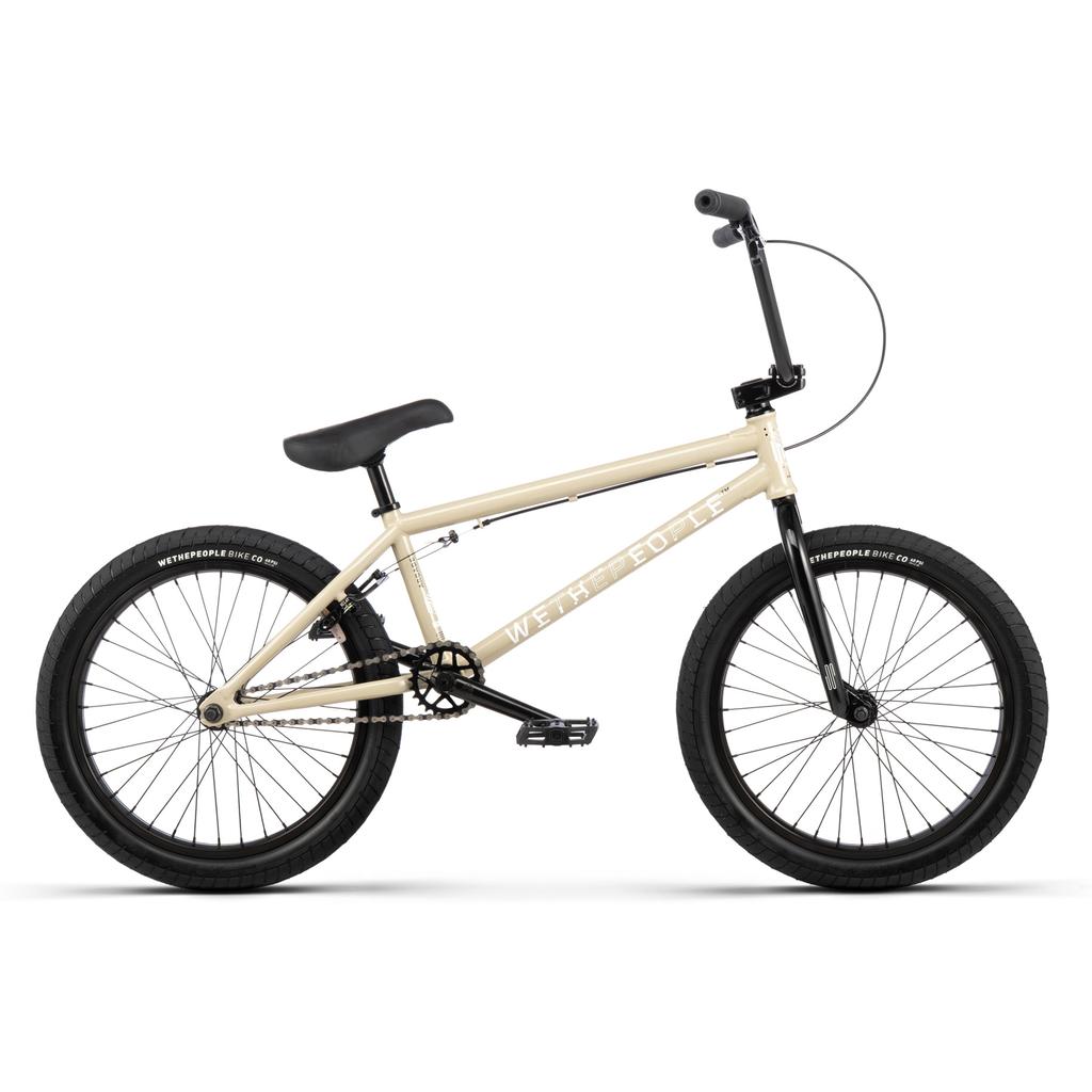 The Wethepeople Arcade 20 Inch BMX Bike is shown in beige with black handlebars, seat, pedals, and tires. Featuring Salt Parts, this mid-tier BMX balances style and quality for enthusiasts. Displayed in profile on a white background.