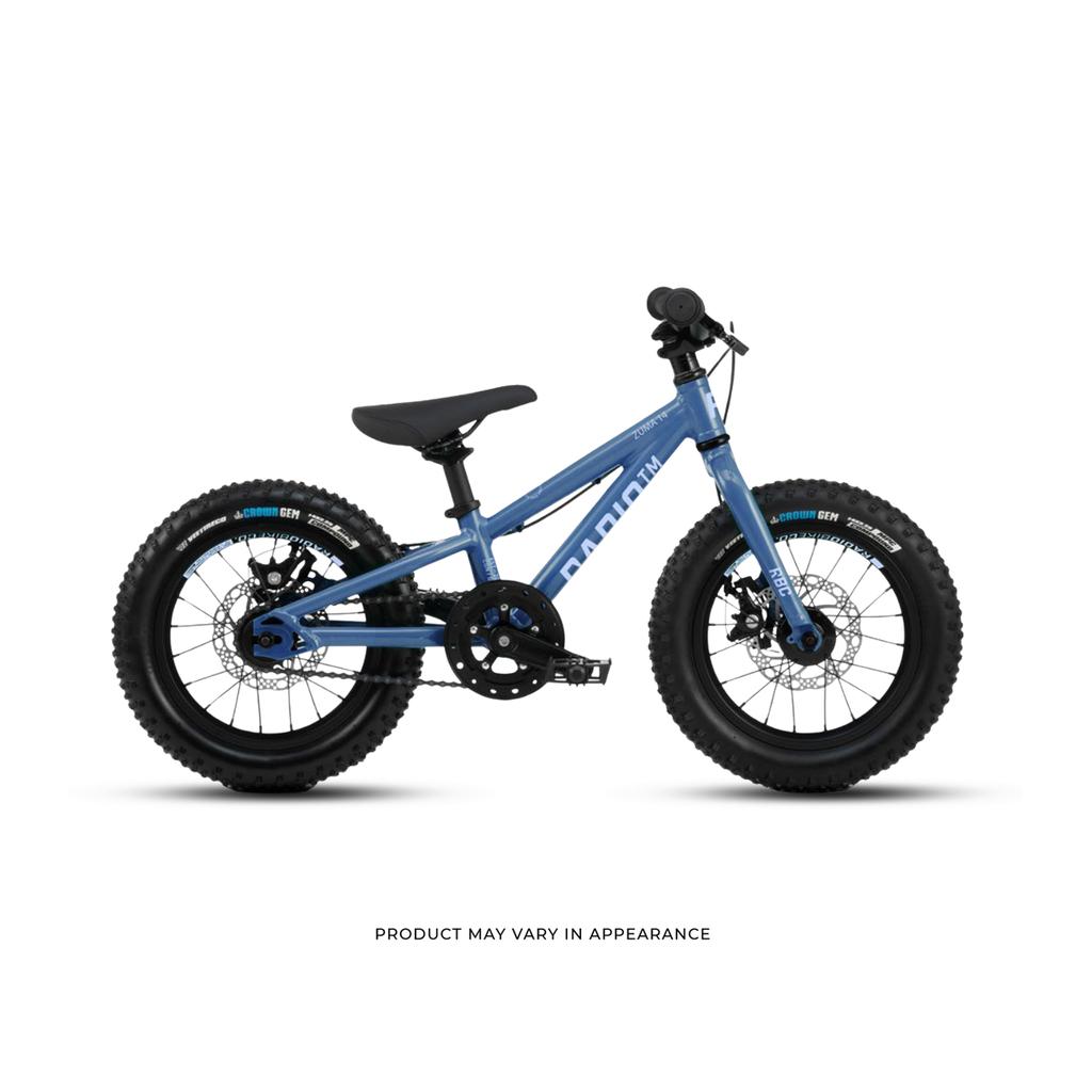 The Radio Zuma 14 Inch Bike is shown in blue with thick black tires, training wheels, and a black seat, displayed in profile on a white background.