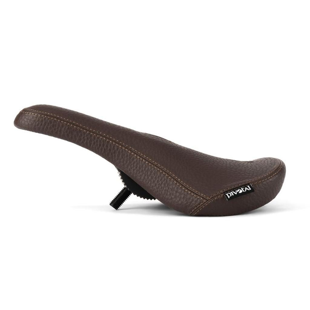 Eclat Exile Pivotal Seat—brown leather ergonomic bicycle seat with visible stitching and a mounting bolt underneath, shown in a side view on a white background.