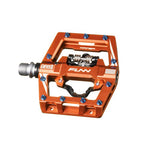 Explore the Funn Mamba S SPD Pedals, ideal for enduro racing, featuring vibrant orange with blue pins, a durable silver axle, and an innovative cut-out design for top performance.