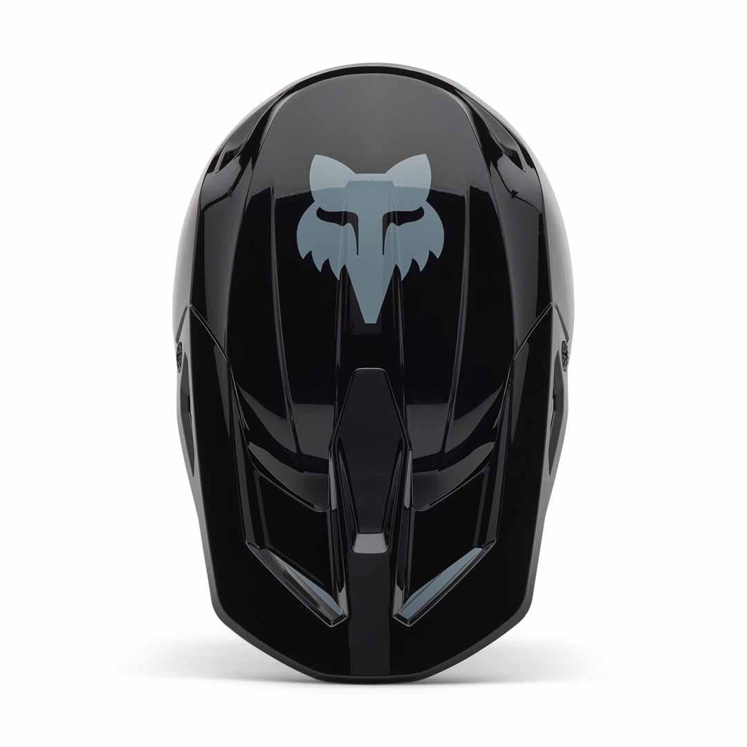 Top view of the Fox YTH V1 Taunt Helmet in glossy black, featuring a bold gray fox head logo—a perfect entry-level BMX helmet for young riders.
