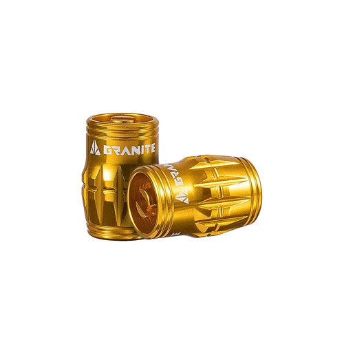 Two gold cylindrical objects with a textured design, branded "Granite Juicy Valve Caps w/ Valve Tool," likely intended for mechanical or automotive applications, potentially as valve core removers in a tubeless setup.