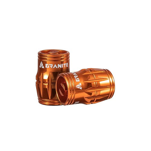 The Granite Juicy Valve Caps with Valve Tool (Pair) are orange metallic, textured for a tubeless setup, and branded with "Granite," adding flair and functionality to your ride.