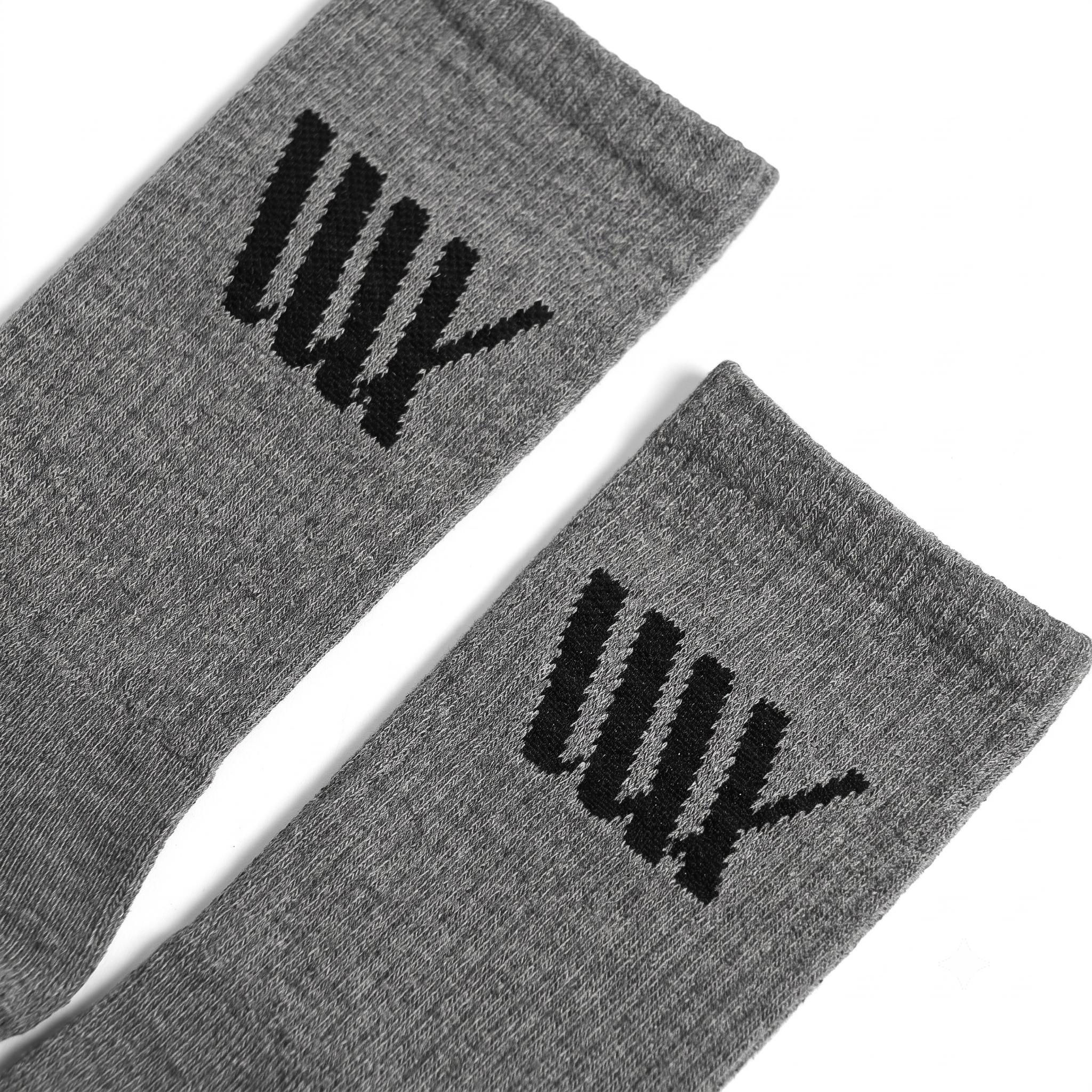 Close-up of two gray LUXBMX Crew Socks made from a durable bamboo blend, featuring a black stylized tally mark design near the top edge on a white background.