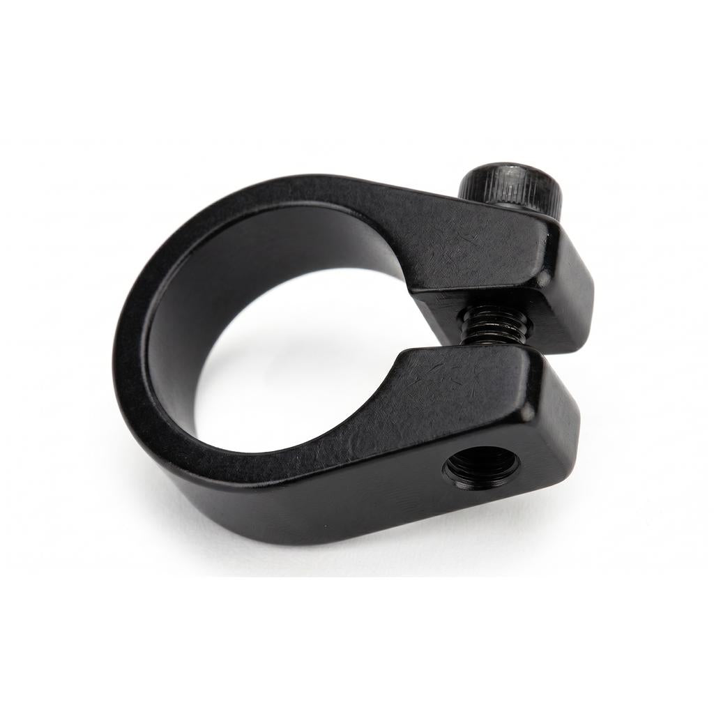 The Alloy Bolt Up Seat Post Clamp, made from black aluminum with a circular opening and tightening screw, securely holds bicycle seat posts. Shown on a white background.