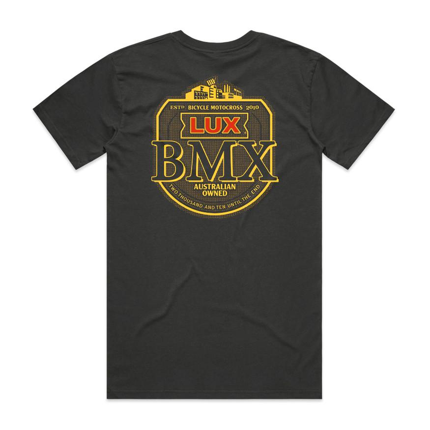 The LUXBMX Gold Tee Coal is a black classic crew t-shirt featuring a bold yellow and red "LUX BMX" logo on the front and “Australian Owned” text on the back, complete with cityscape details that celebrate this Brisbane icon and showcase its “Bicycle Motocross 2010” heritage.