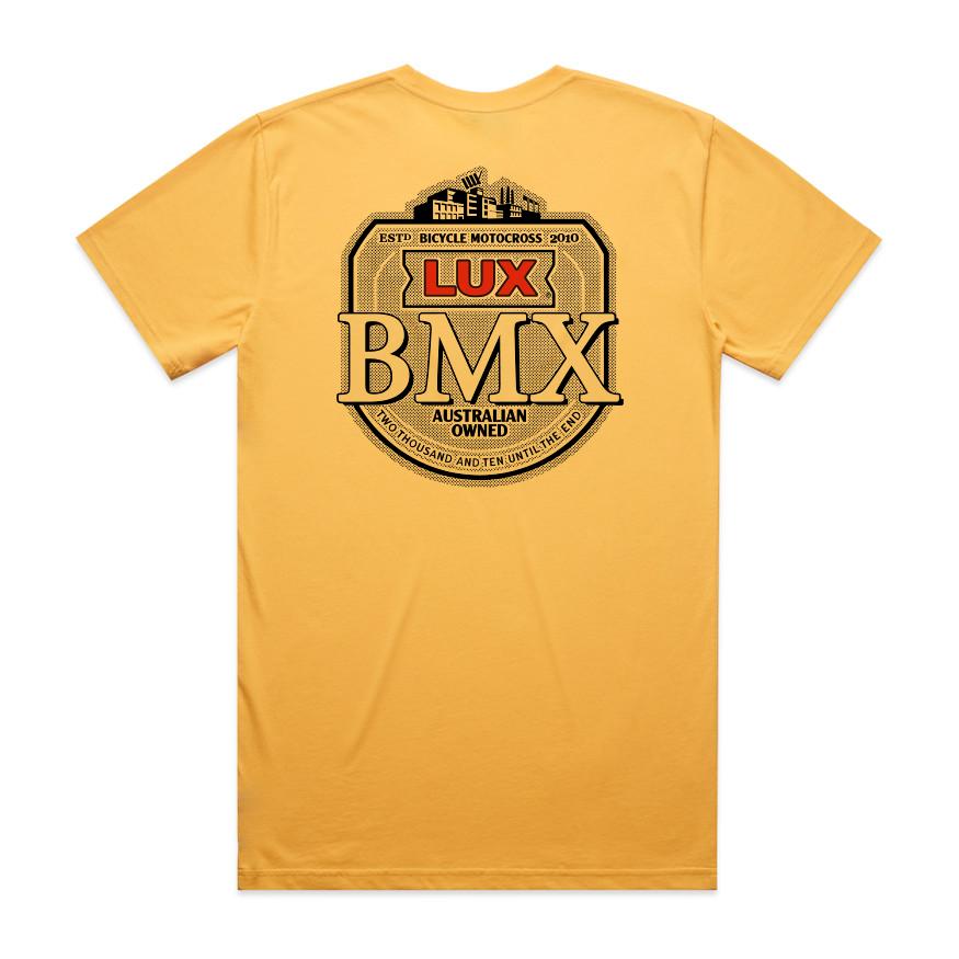 The LUXBMX Gold Tee Sunset is a classic yellow crew tee featuring a large circular LUX BMX badge and bold "Australian Owned" text printed in black and red on the back—truly a Brisbane icon.