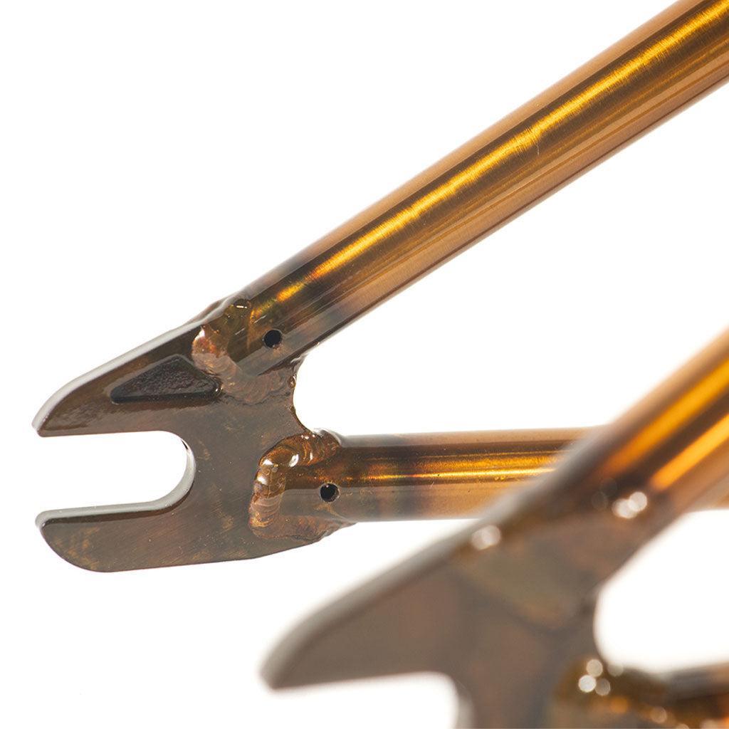 Close-up of the Colony 2024 Sweet Tooth Frame's metallic dropouts, highlighting its chromoly build with a shiny gold finish and intricate welding.