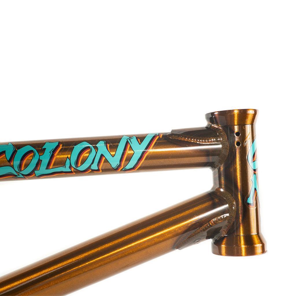 Close-up of the Colony 2024 Sweet Tooth Frame, featuring a chromoly construction with "Colony BMX" in teal and orange lettering against a brown background.