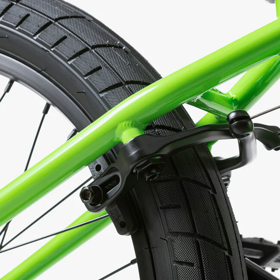 A close up of a green Wethepeople Nova 20 Inch BMX Bike with black wheels.