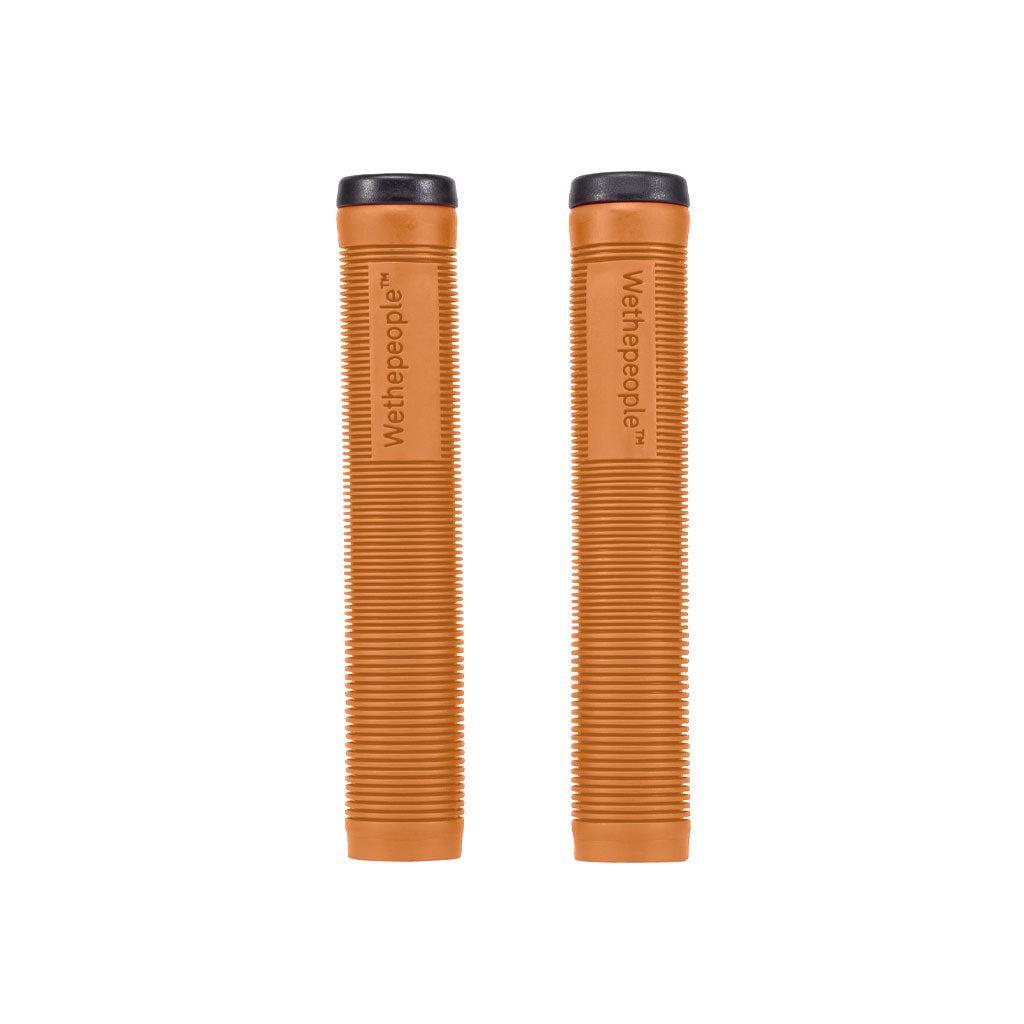 Two Wethepeople Perfect Grips, crafted from super-soft brown rubber with ribbed texture and black end caps, are displayed vertically against a white background. Ideal for cycling enthusiasts, they combine comfort and style.
