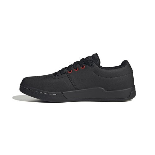 The Five Ten Freerider Pro Flat Core Shoes in black/white feature a low-top design, red eyelets, and a flat sole for optimal pedal grip—shown in a side view on white and inspired by top mountain bike shoes.