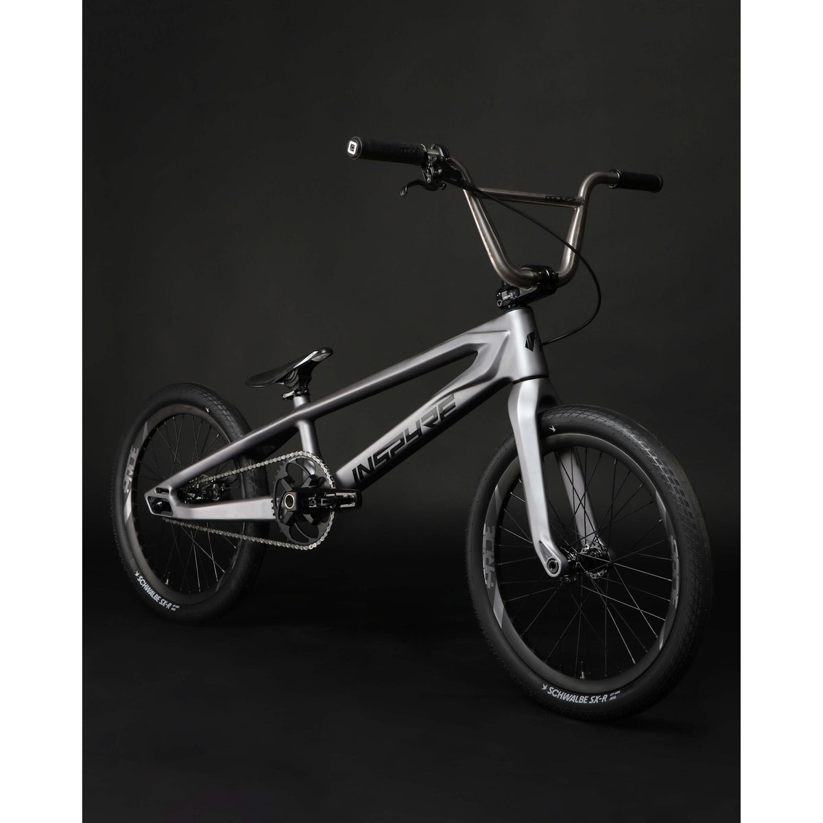 A matte gray Inspyre ERA Carbon Pro XXXXL frameset BMX bike with black handlebars and black wheels on a dark background.