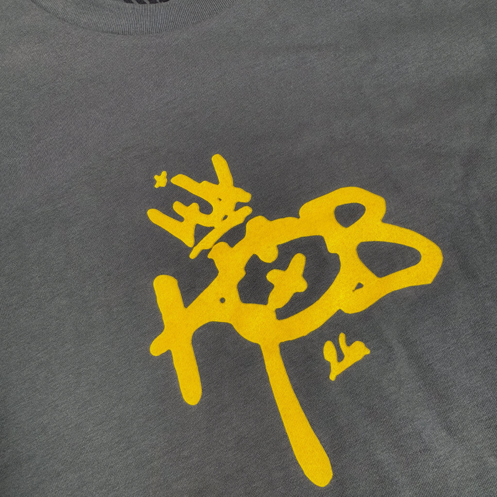 LUXBMX King of BNE 2026 T-Shirt Dark Grey / Yellow features bold yellow graffiti text and a crown graphic, perfect for the 2026 King’s Birthday celebration.