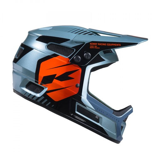 The Kenny Racing Elite Helmet Graphic Sunset is a full-face motocross helmet featuring a gray and black base with bold orange and black graphic accents, vent openings, and a sleek side profile. Engineered for lightweight durability and comfort, it’s an excellent choice for riders seeking both style and reliable protection.