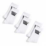 Three pairs of LUXBMX Crew Socks (3 pack) in white, arranged in two rows. Each sock features a bold black logo on the cuff—ideal for BMX riding.
