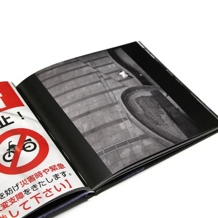 The MAINTAIN - IV.V "DERAILED" Book by Rob Dolecki features a black-and-white photo of tiled pavement and steps, partial Japanese text, and a red "no bicycles" icon on the left page.