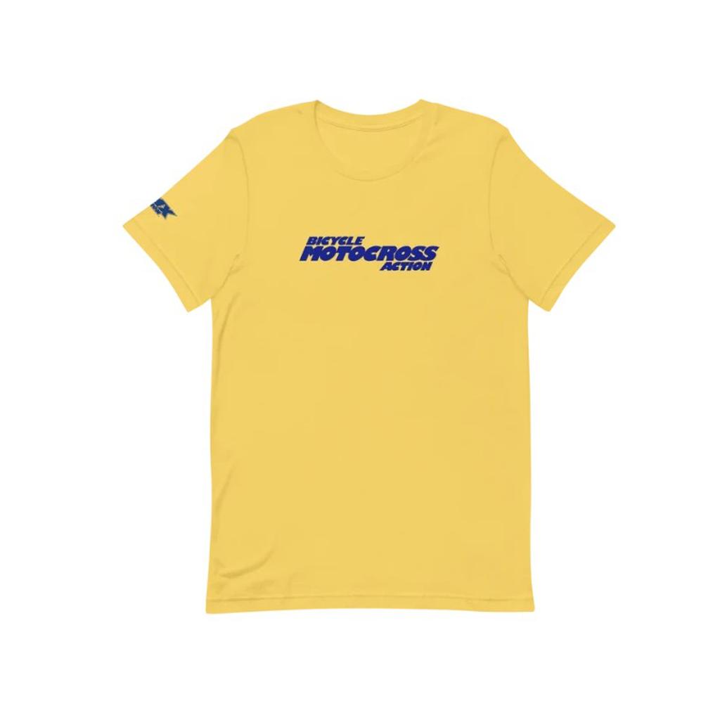 The MCS BMXA Logo T-Shirt is a yellow tee made from soft Airlume cotton, featuring bold blue "Bicycle Motocross Action" lettering on the front and a small blue graphic on the left sleeve.
